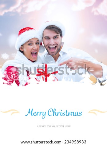 festive young couple holding gift against border
