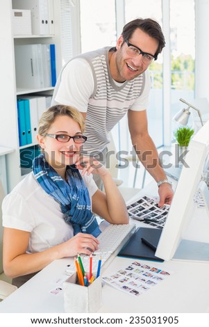 Smiling photo editors using computer in their office