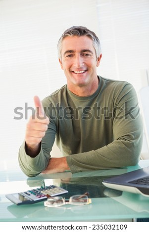 Positive casual man with his thumb up in his office