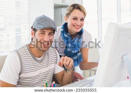 Editorial team working together smiling at camera in office
