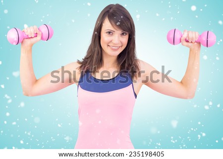 Smiling woman holding hand weight against blue vignette
