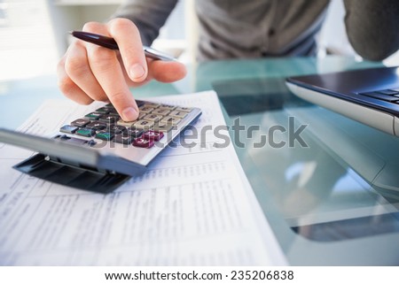 Casual businessman calculating his expenses in the office