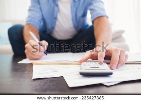 Focused man figuring out his finances in the living room