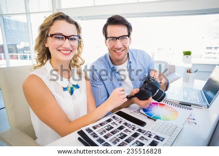 Portrait of photo editors with camera in their office