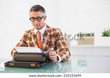 Smiling vintage man using typewriter in his office