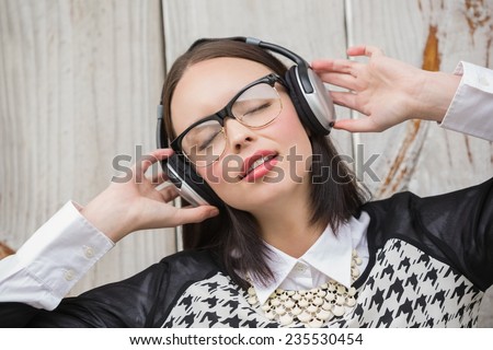 Pretty hipster listening to music against bleached wooden planks