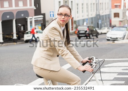 Young businesswoman riding her bike outside in the city