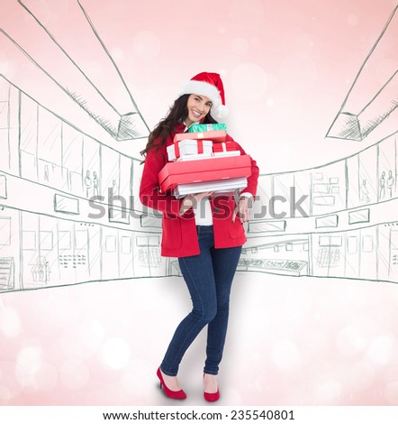 Festive brunette in santa hat and red coat holding pile of gifts against blue abstract light spot design