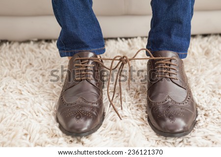 Classy mans shoelaces tied together at home in the living room