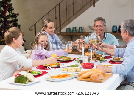 Family toasting with white wine in a christmas dinner at home in the living room