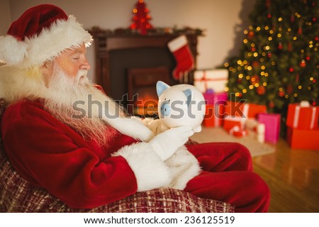 Father christmas holding piggy bank at home in the living room