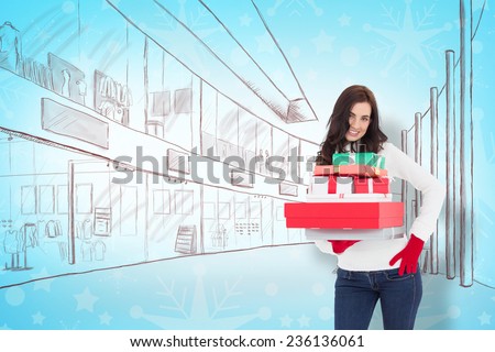 Pretty brunette posing and holding pile of gifts against snowflake wallpaper pattern