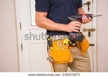 Construction worker drilling hole in wall in a new house