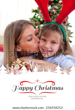 Loving mother kisses daughter at Christmas against border