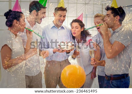 Casual businessmen team celebrating a birthday against colourful fireworks exploding on black background