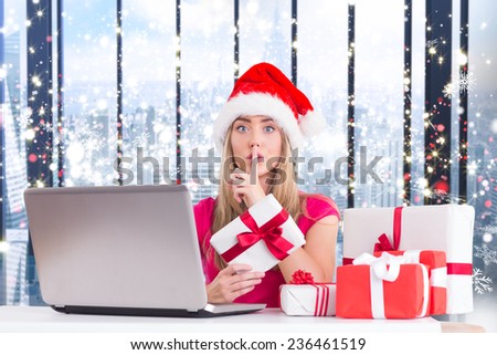 Festive blonde shopping online with laptop against glittering lights in room