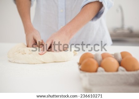 Woman kneading dough on counter at home in the kitchen
