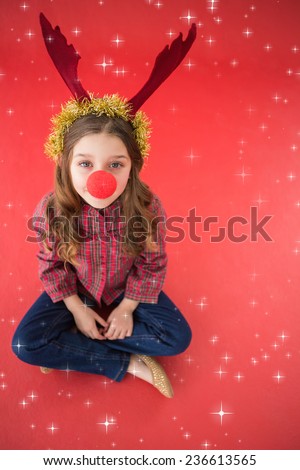 Festive little girl wearing red nose against twinkling stars