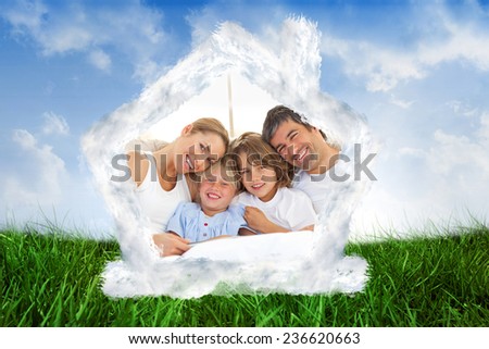 Happy family reading a book on bed against field of grass under blue sky
