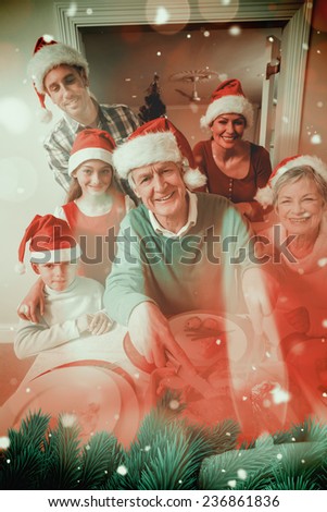 Grandfather in santa hat carving chicken at christmas dinner against candle burning against festive background