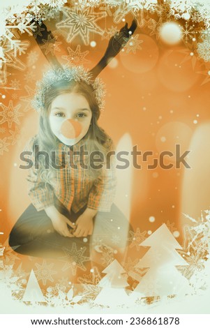 Festive little girl wearing red nose against candle burning against festive background
