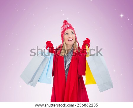 Blonde in winter clothes holding shopping bags on vignette background