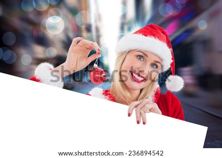 Festive blonde showing white card against blurry new york street