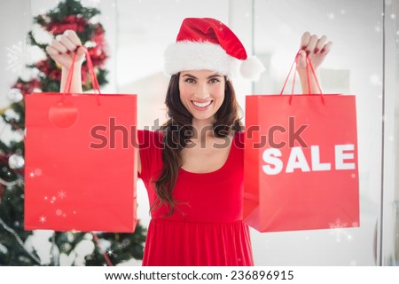 Brunette showing sale bag and shopping bag against snow falling