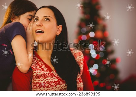 Daughter telling her mother a christmas secret against snowflakes