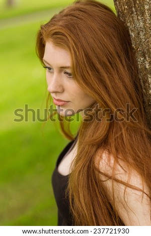 Close up side view of beautiful young woman in the park