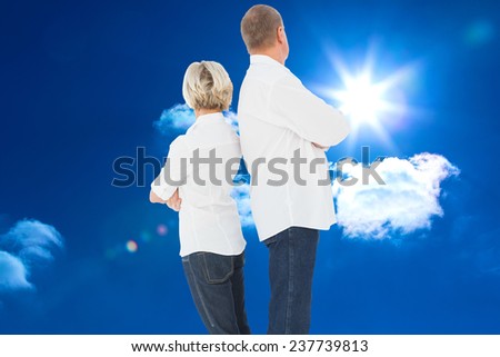 Upset couple not talking to each other after fight against bright blue sky with clouds