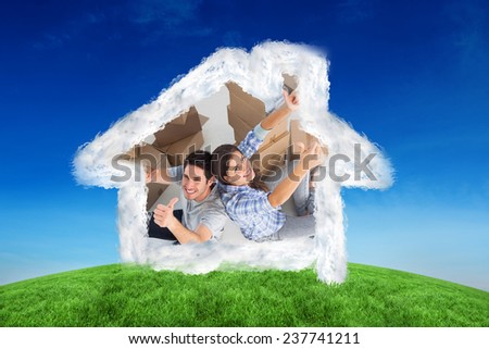 Overview of a happy couple giving thumbs up against green hill under blue sky