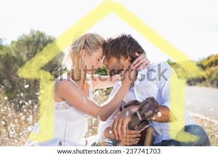 Handsome man serenading his girlfriend with guitar against house outline
