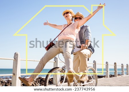 Happy casual couple going for a bike ride on the pier against house outline