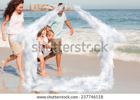 Family running on the beach against house outline in clouds