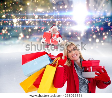 Festive blonde holding many gifts against santa delivering gifts in city