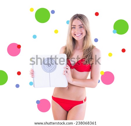 Fit blonde in red bikini showing scales against dot pattern