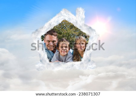 Happy family lying on the grass against blue sky with white clouds