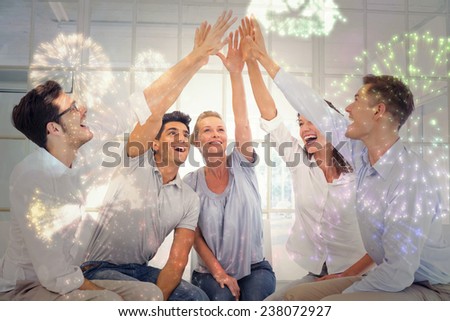 Group therapy in session sitting in a circle high fiving against colourful fireworks exploding on black background