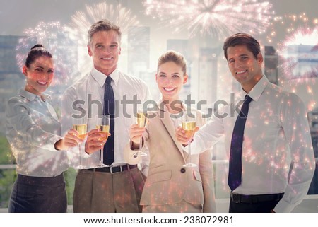 Smiling team of business people honoring a success with champagne against colourful fireworks exploding on black background
