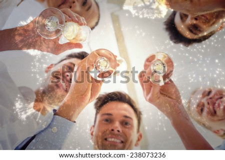 Casual business team toasting with champagne against white fireworks exploding on black background