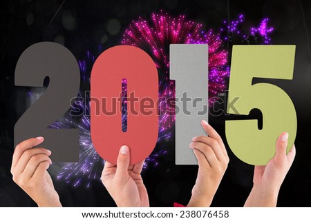 Hands holding poster against colourful fireworks exploding on black background