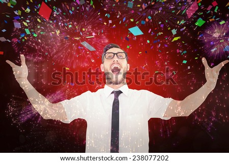 Geeky young businessman with arms out against colourful fireworks exploding on black background