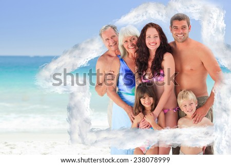 Portrait of a joyful family at the beach against house outline in clouds