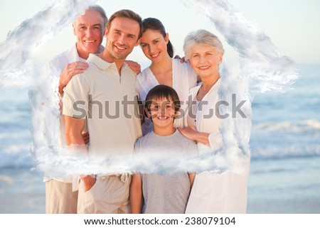 Portrait of a smiling family at the beach against house outline in clouds