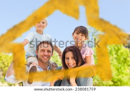Parents giving children a piggyback against house outline in clouds