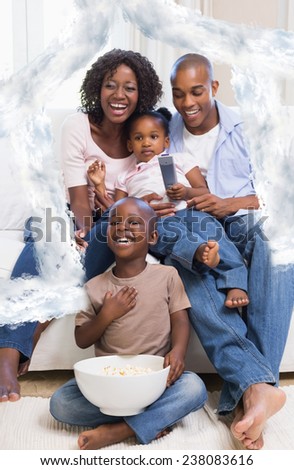 Happy family watching television together against house outline in clouds