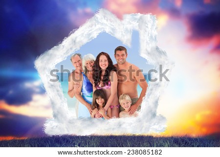 Portrait of a joyful family at the beach against blue and orange sky with clouds