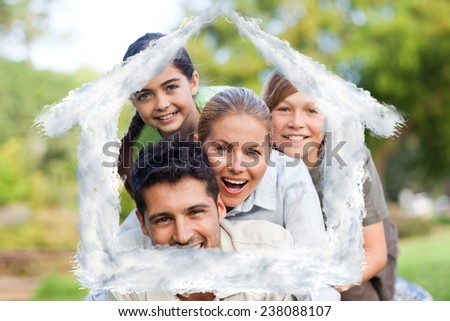Happy family in the park against house outline in clouds