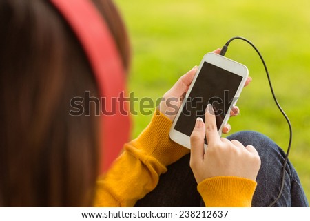 Close up of relaxed young woman enjoying music in the park